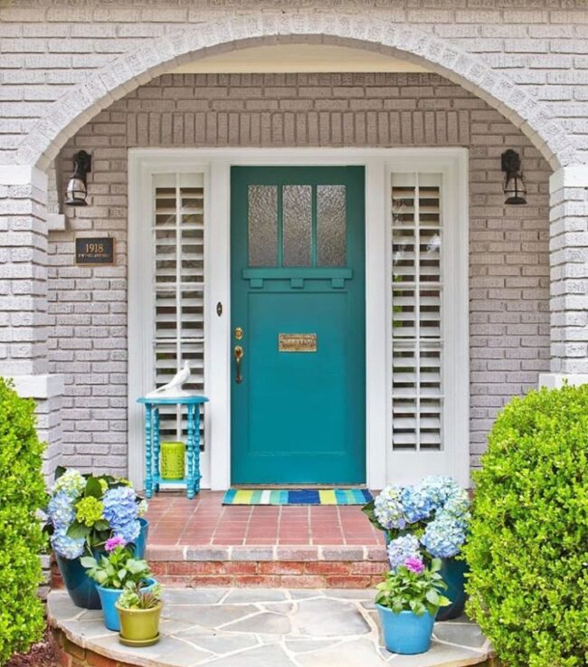 Teal Door Charm Meets Gray Facade
